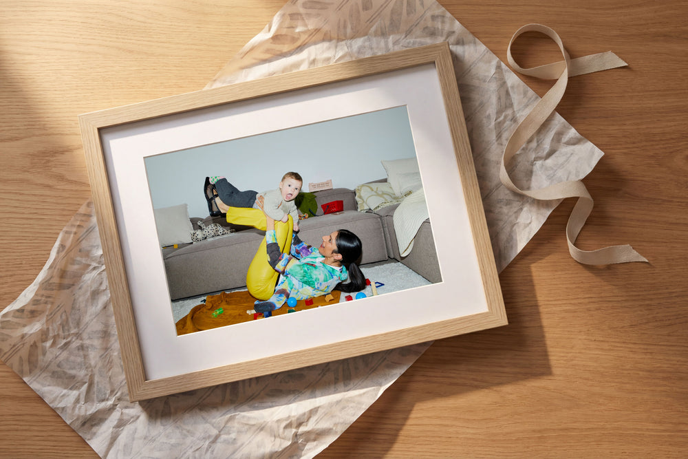Framed artwork on a wooden surface with a ribbon
